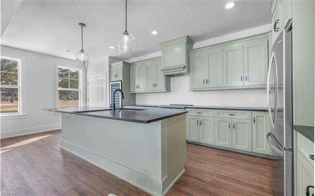 kitchen with sink, pendant lighting, stainless steel fridge, and dark wood-type flooring