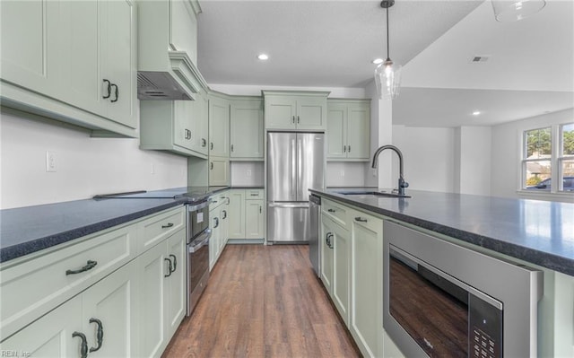 kitchen featuring stainless steel appliances, premium range hood, pendant lighting, dark wood-type flooring, and sink