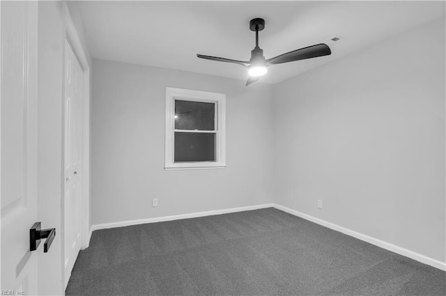 unfurnished room with ceiling fan and dark colored carpet