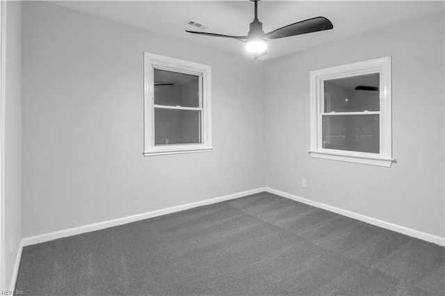 spare room featuring ceiling fan and dark colored carpet