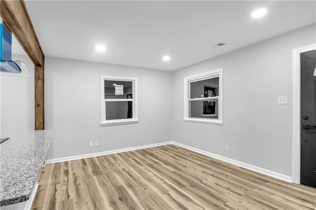 empty room featuring light hardwood / wood-style floors and built in shelves