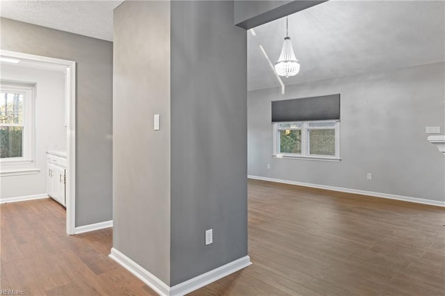 interior space featuring a textured ceiling, an inviting chandelier, and hardwood / wood-style flooring