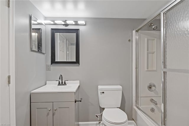 full bathroom featuring toilet, bath / shower combo with glass door, and vanity