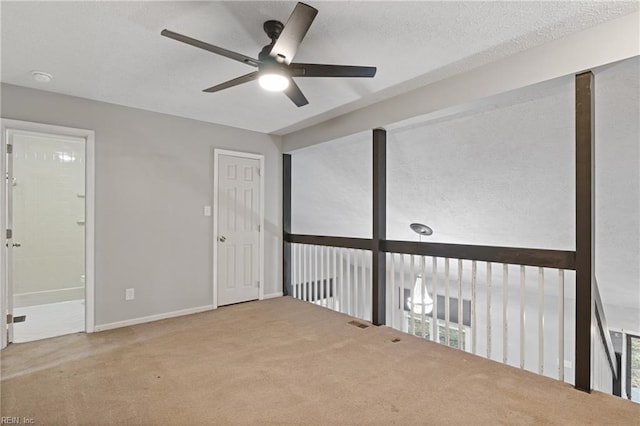 empty room featuring ceiling fan, carpet, and plenty of natural light