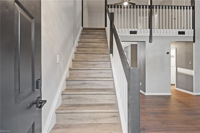 stairs featuring hardwood / wood-style floors and a towering ceiling