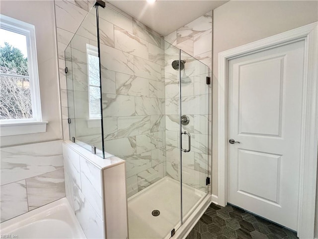 bathroom with shower with separate bathtub and a wealth of natural light