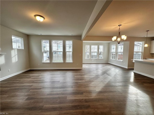 unfurnished living room with a notable chandelier and dark hardwood / wood-style flooring