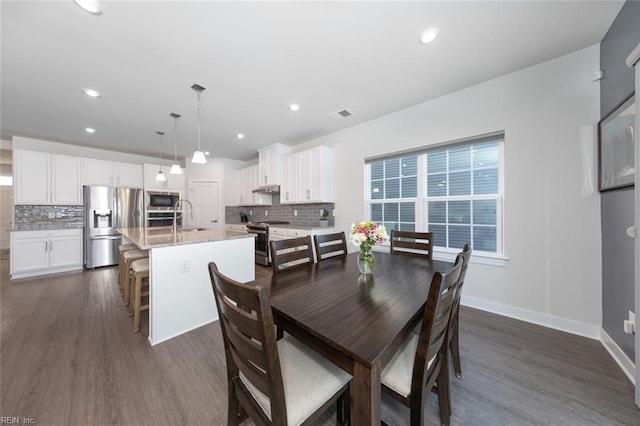 dining area featuring dark wood-type flooring and sink