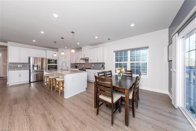 dining space with sink and light hardwood / wood-style flooring