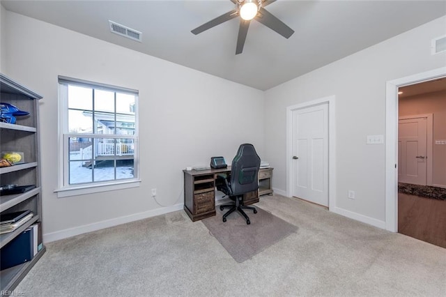 carpeted home office featuring ceiling fan