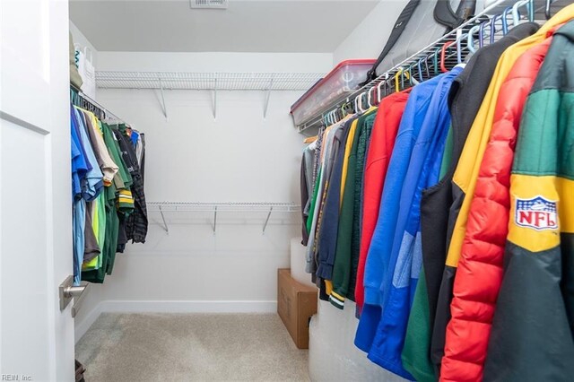 walk in closet featuring light carpet