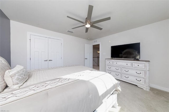 bedroom with ceiling fan, a closet, and light colored carpet