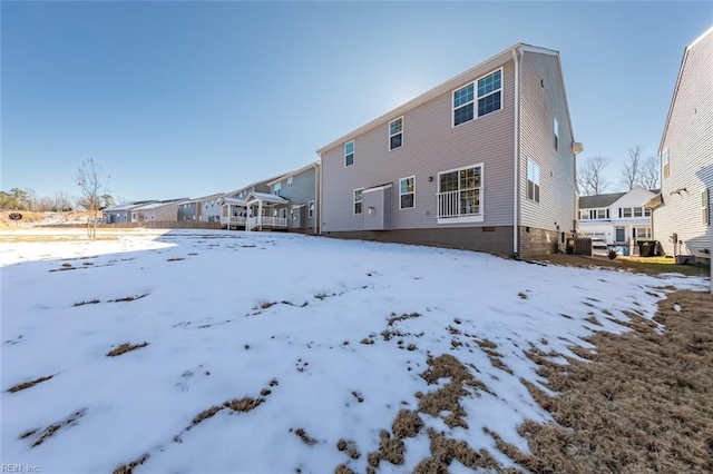 snow covered rear of property featuring central air condition unit