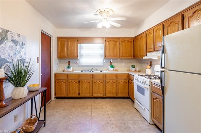 kitchen with decorative backsplash, gas range gas stove, fridge, ceiling fan, and sink