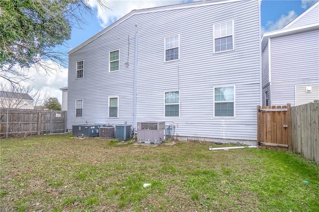 back of house featuring a yard and central AC