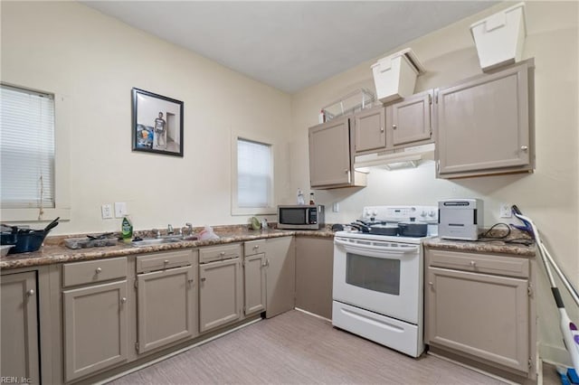 kitchen with light hardwood / wood-style floors, sink, electric range, and gray cabinets