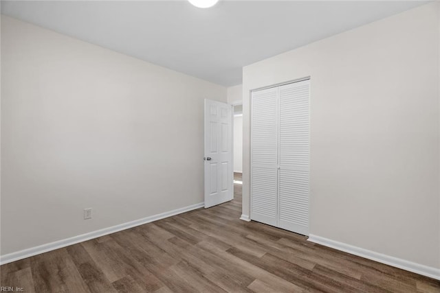 unfurnished bedroom with wood-type flooring and a closet