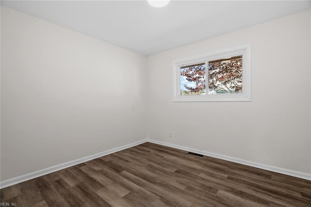 spare room with dark wood-type flooring