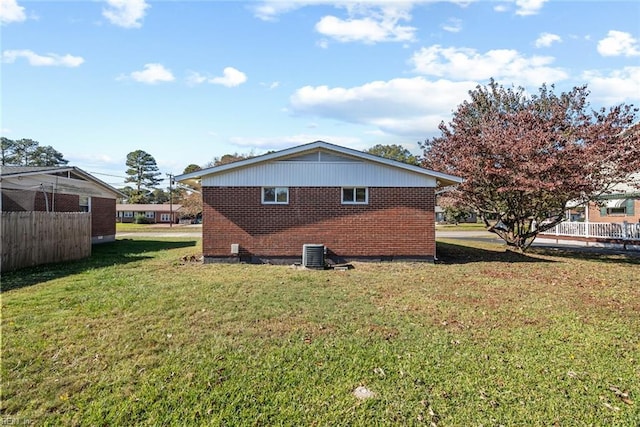 exterior space with central AC unit and a lawn