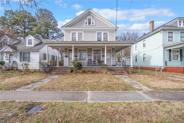 view of front of house featuring covered porch and a front lawn