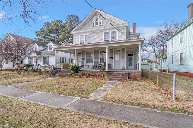 view of front of home with covered porch and a front yard