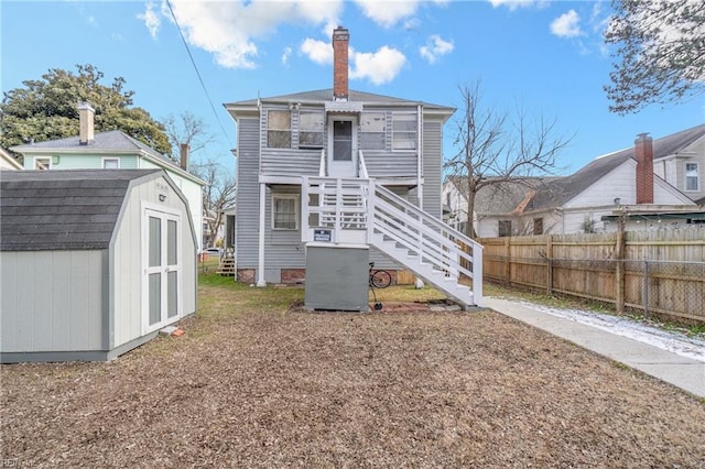 back of house with a shed