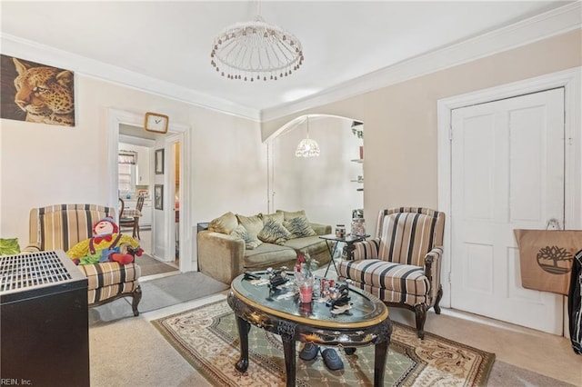 carpeted living room featuring crown molding and a notable chandelier