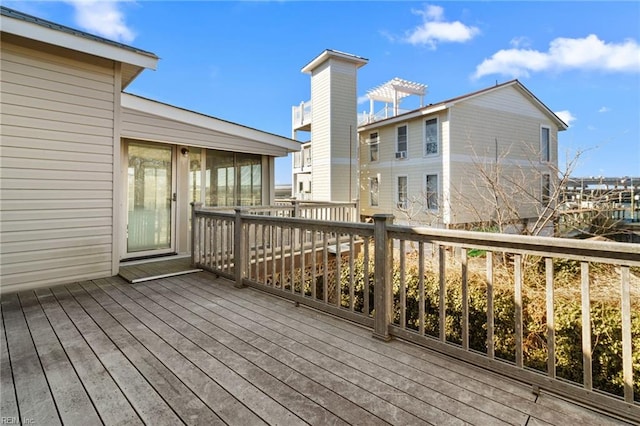 wooden deck with a sunroom and a pergola