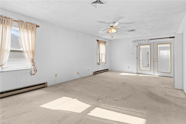 carpeted empty room featuring ceiling fan, french doors, and a baseboard heating unit