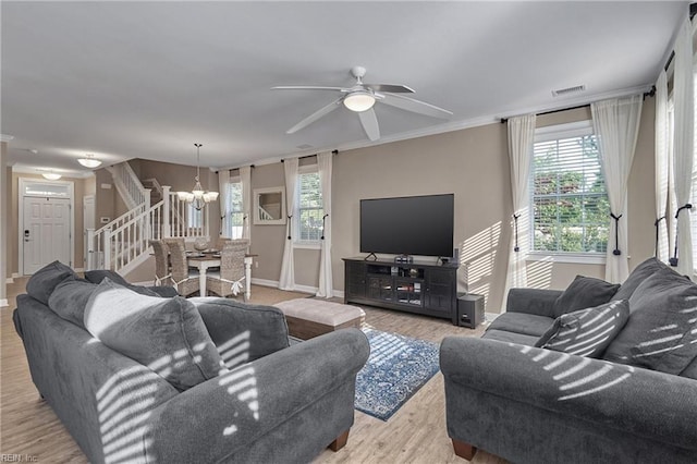 living room with ceiling fan with notable chandelier, light wood-type flooring, and ornamental molding