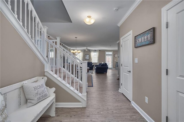 interior space with wood-type flooring, a chandelier, and crown molding