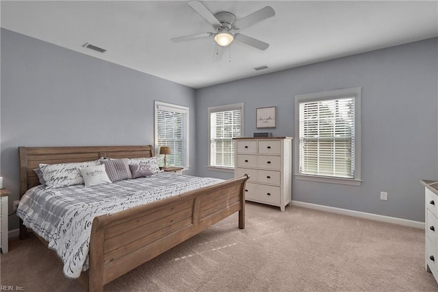 bedroom featuring light colored carpet, ceiling fan, and multiple windows