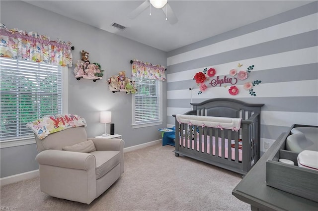 bedroom with ceiling fan, carpet floors, and a nursery area