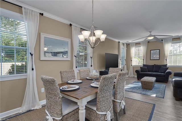 dining area with ceiling fan with notable chandelier, crown molding, and hardwood / wood-style floors