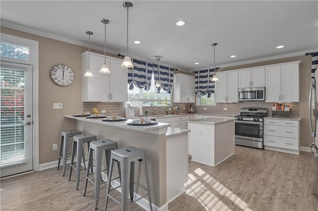 kitchen featuring stainless steel appliances, white cabinets, and kitchen peninsula