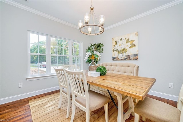 dining area featuring crown molding, wood finished floors, and baseboards