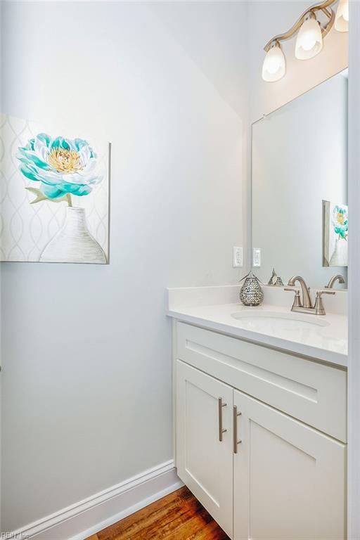 bathroom with vanity, baseboards, and wood finished floors