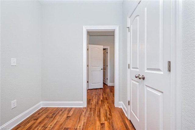 hall with wood finished floors and baseboards