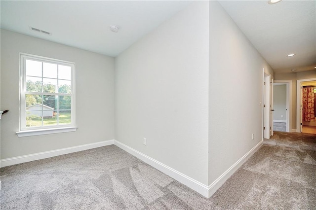 carpeted empty room with baseboards, visible vents, and recessed lighting