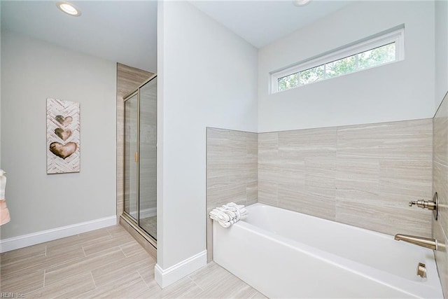 bathroom featuring a stall shower, recessed lighting, a bath, and baseboards