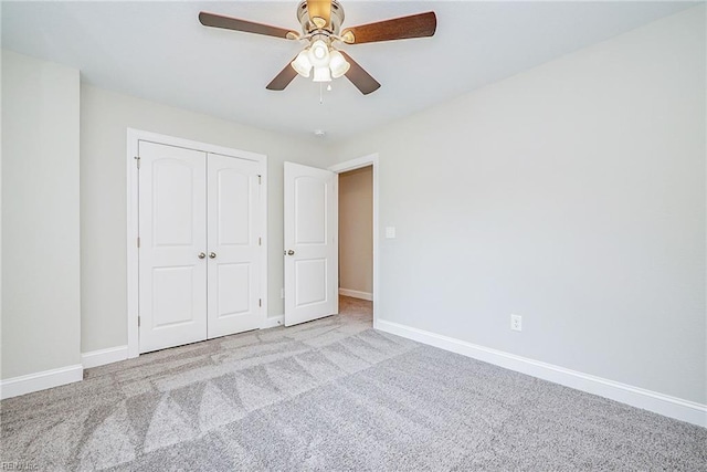 unfurnished bedroom featuring a closet, carpet, a ceiling fan, and baseboards