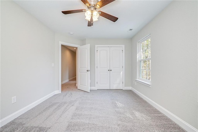 unfurnished bedroom featuring ceiling fan, a closet, carpet, and baseboards