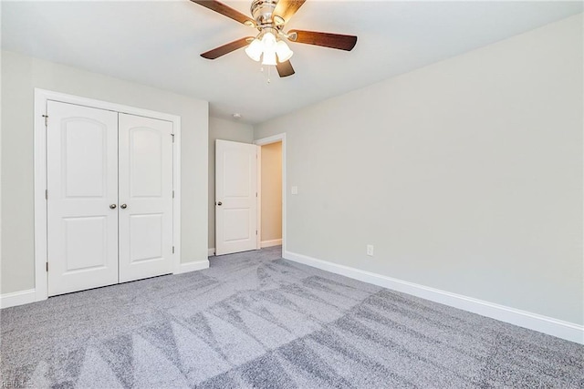 unfurnished bedroom featuring ceiling fan, a closet, baseboards, and carpet flooring