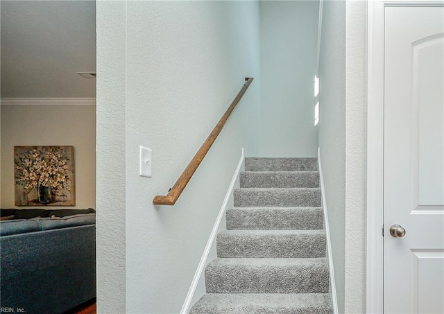 staircase with ornamental molding and baseboards