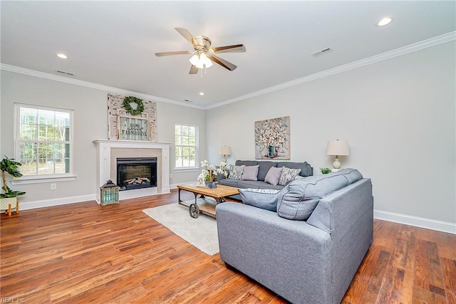 living area featuring visible vents, baseboards, and wood finished floors