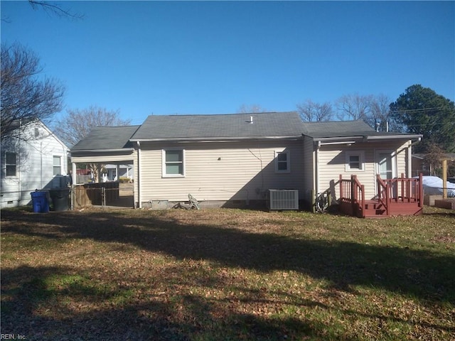 back of house with central AC unit and a lawn