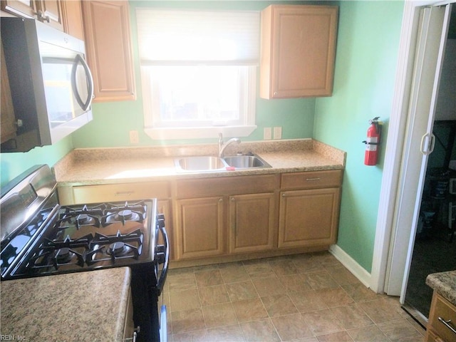 kitchen with sink, light brown cabinetry, and gas range oven