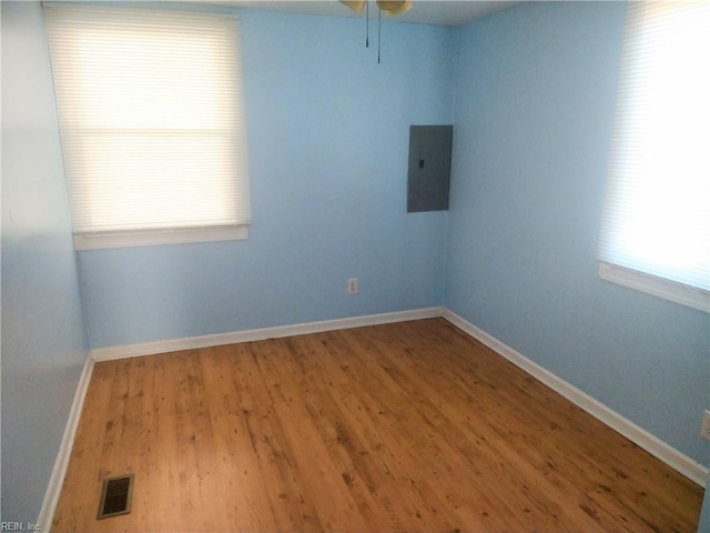 spare room featuring electric panel and wood-type flooring