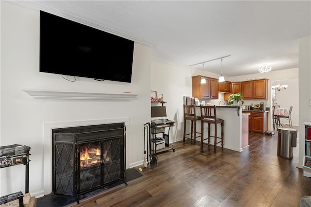 living room with dark hardwood / wood-style floors, crown molding, and rail lighting