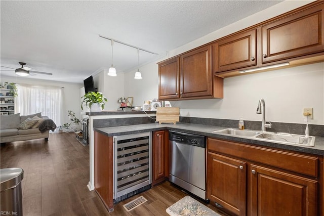 kitchen with rail lighting, dark wood-type flooring, wine cooler, stainless steel dishwasher, and sink